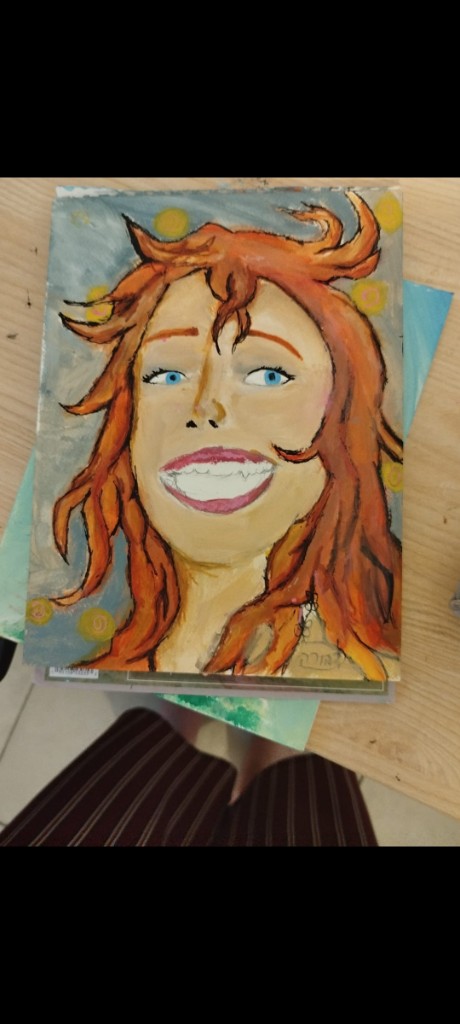 Expressive portrait of a smiling woman with wild orange hair and blue eyes